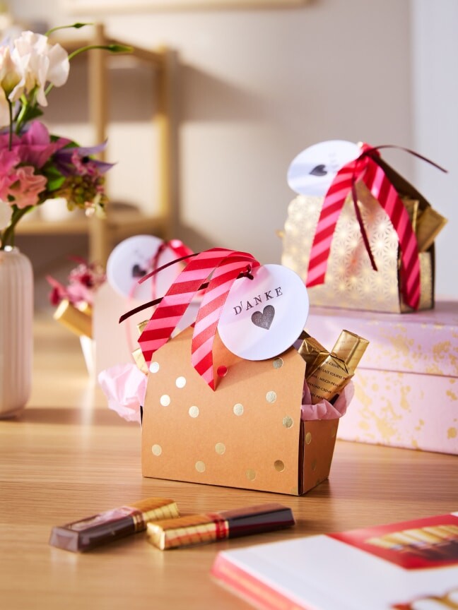 Eine Überraschungstüte, innen einzelne Finest Selection Stäbchen, oben einer Schleife und einem runden Papierschild mit der Aufschrift: Danke