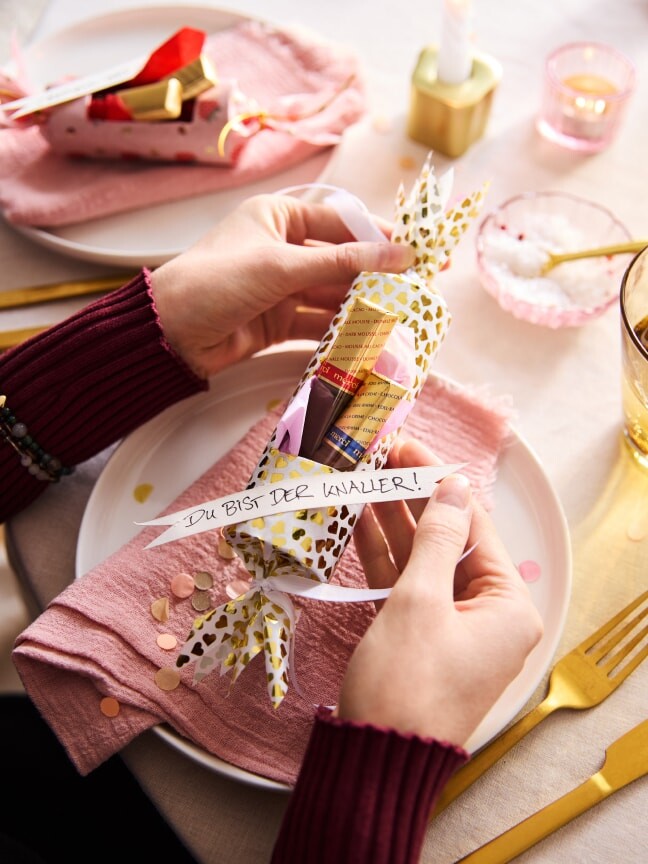 Ein Bonbon Seidenpapier mit Schleife oben und unten, innen mit Finest Selection und Geschenkpapier. mit der Aufschrift: Du bist der Knaller
